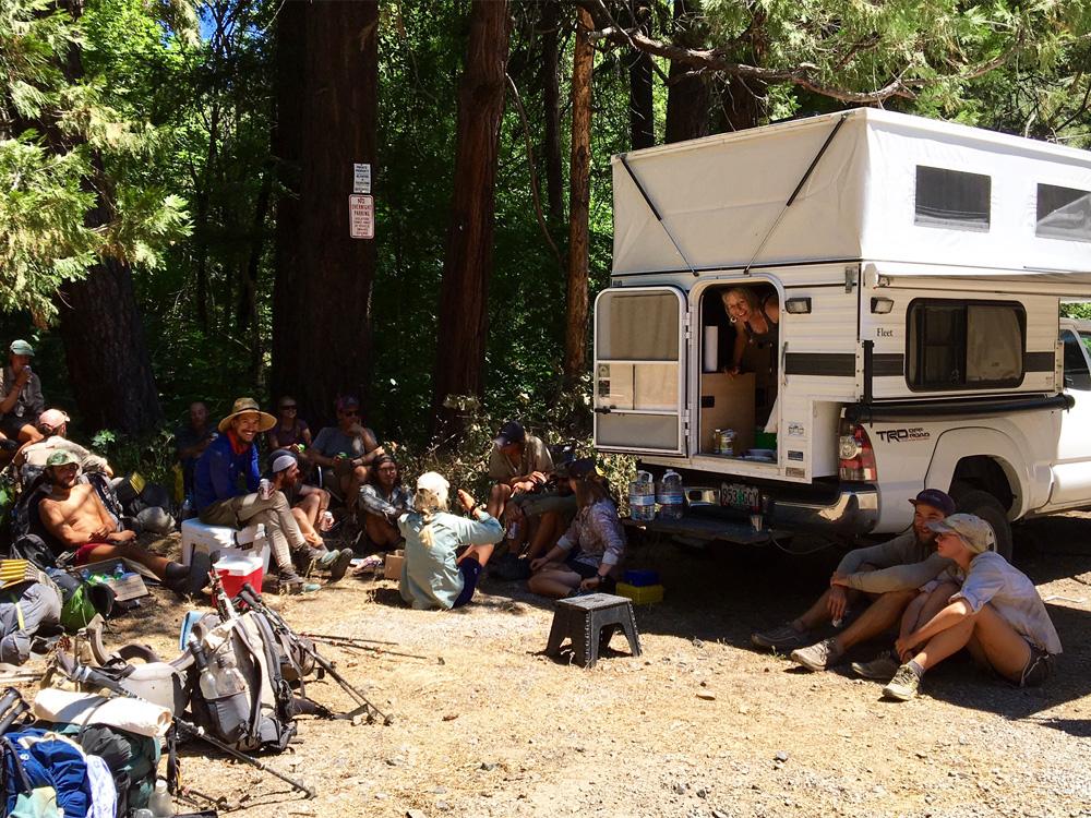 a bunch of people having a good time camping with a pop up truck camper