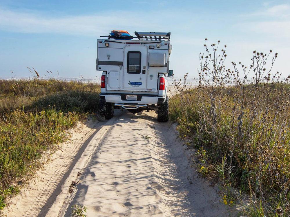 truck with pop up trailer driving to the ocean